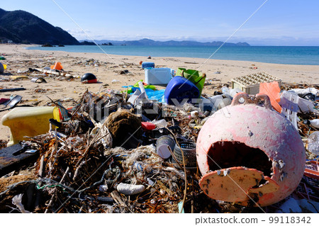 Marine debris washed ashore on a beautiful crystal beach 99118342