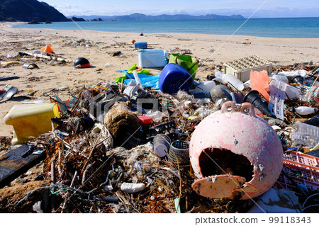 Marine debris washed ashore on a beautiful crystal beach 99118343