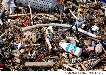 Marine debris washed ashore on a beautiful crystal beach 99118347