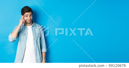 Young thoughtful man pointing at head, asking to think about it, giving a hint, standing in casual clothes over blue background Young thoughtful man pointing at head, asking to think about it, giving a hint, standing in casual clothes over blue background 99120676