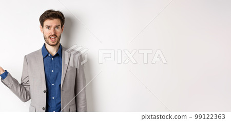 Whats wrong. Confused guy in suit cant understand, looking clueless with hand raised up, staring at camera questioned, standing on white background Whats wrong. Confused guy in suit cant understand, looking clueless with hand raised up, staring at camera questioned, standing on white background 99122363