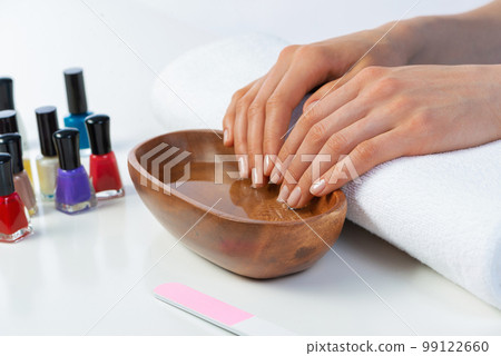 Closeup female hands in wooden bowl with water Closeup female hands in wooden bowl with water 99122660