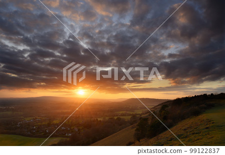 Glowing sunset view from Colley Hill between Reigate and Dorking in Surrey, UK. Surrey Hills area of Outstanding Natural Beauty on the North Downs. Looking towards Leith Hill on the Greensand Ridge. Glowing sunset view from Colley Hill between Reigate and Dorking in Surrey, UK. Surrey Hills area of Outstanding Natural Beauty on the North Downs. Looking towards Leith Hill on the Greensand Ridge. 99122837