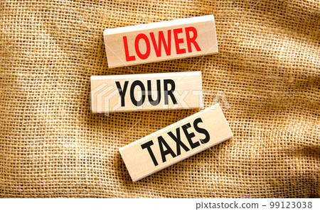 Lower your taxes symbol. Concept words Lower your taxes on wooden blocks on a beautiful canvas table canvas background. Business tax lower your taxes concept. Copy space. 99123038