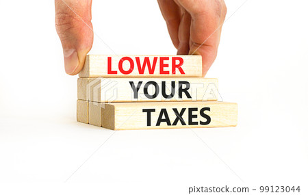 Lower your taxes symbol. Concept words Lower your taxes on wooden blocks on a beautiful white table white background. Businessman hand. Business tax lower your taxes concept. Copy space. Lower your taxes symbol. Concept words Lower your taxes on wooden blocks on a beautiful white table white background. Businessman hand. Business tax lower your taxes concept. Copy space. 99123044