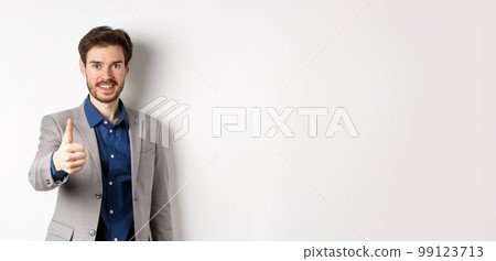 Image of handsome businessman in suit showing thumb up and smiling, standing on white background Image of handsome businessman in suit showing thumb up and smiling, standing on white background 99123713