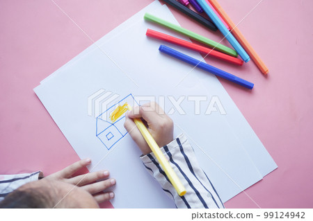 top view of child girl drawing on paper sitting on floor  99124942