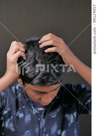 teenage boy Scratching Head Against black background . teenage boy Scratching Head Against black background . 99124957