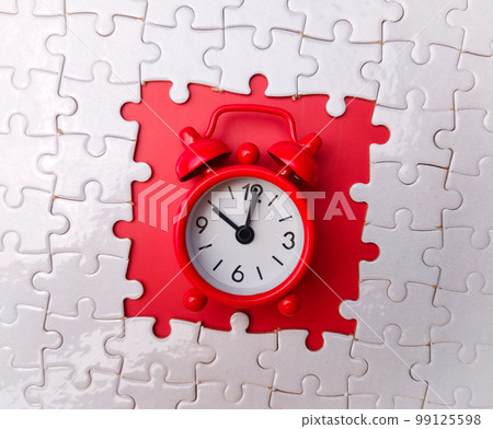 Concept red alarm clock and puzzle on red background Concept red alarm clock and puzzle on red background 99125598