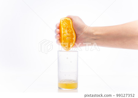 Male hand squeezing orange juice 99127352