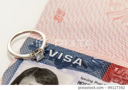 Close-up of a diamond ring on a US visa as an idea for a marriage move 99127392