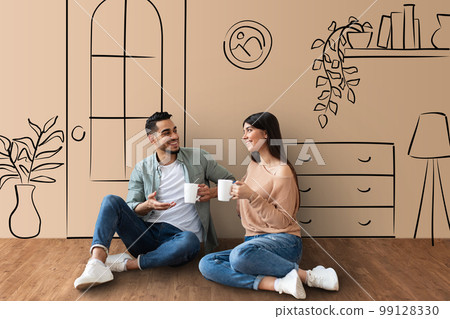 Loving middle eastern couple sitting on floor, drinking tea Loving middle eastern couple sitting on floor, drinking tea 99128330