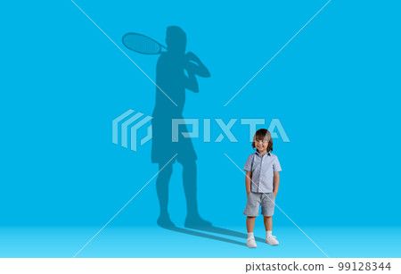 Tennis player shadow over cute smiling preschool boy 99128344