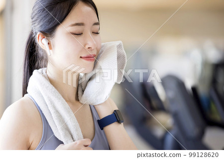 Young woman wiping sweat at the gym 99128620