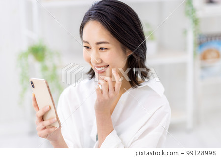 一個操作智能手機的年輕女子 99128998