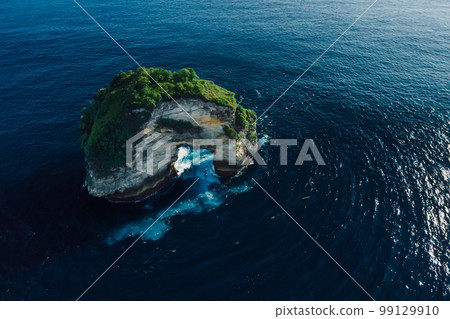 Scenic rocky island in ocean nearby Nusa Penida. Aerial view Scenic rocky island in ocean nearby Nusa Penida. Aerial view 99129910