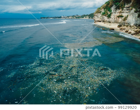 Ocean in Bali and plastic trash, aerial view. Dirty plastic bottles and bags on a garbage. Ocean pollution, plastic in water. Ocean in Bali and plastic trash, aerial view. Dirty plastic bottles and bags on a garbage. Ocean pollution, plastic in water. 99129920