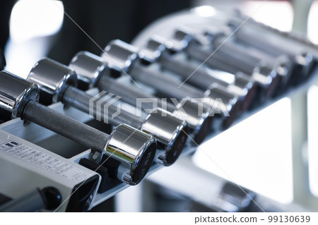 Dumbbells placed on a dumbbell rack in a fitness gym Dumbbells placed on a dumbbell rack in a fitness gym 99130639