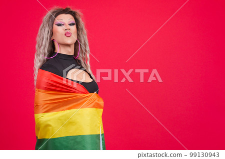 Transgender person kissing while wrapping with a rainbow lgbt flag 99130943