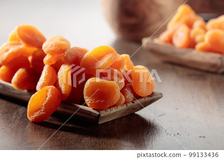 Dried apricots in a wooden dish. Dried apricots in a wooden dish. 99133436