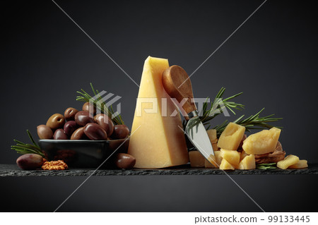 Parmesan cheese with knife, olives, and rosemary. Parmesan cheese with knife, olives, and rosemary. 99133445
