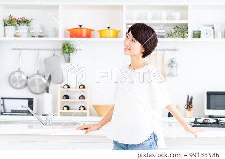 Middle-aged woman in the kitchen Middle-aged woman in the kitchen 99133586