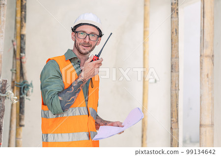 portrait builder professional engineer architect foreman hipster worker work in construction site, talk radio operation 99134642