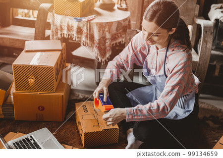 woman packing products order box send to customer freelance work for own business at home vintage tone 99134659