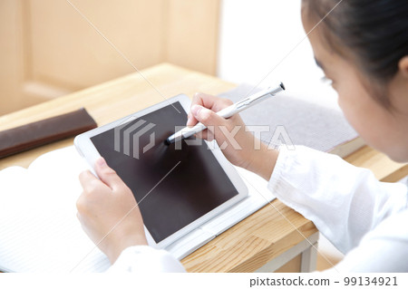 Elementary school girl studying with a tablet Elementary school girl studying with a tablet 99134921