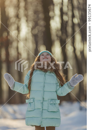 girl in a turquoise squat and a hat in the winter forest 99135674