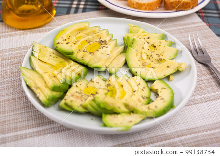 ripe avocado pulp cut into pieces sprinkled with lemon juice on a plate 99138734