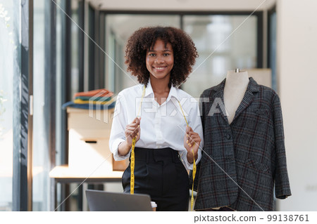 Portrait of young african american woman fashion designer stylish working at fashion studio. Portrait of young african american woman fashion designer stylish working at fashion studio. 99138761