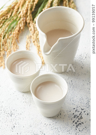 將甘酒倒入杯子中 將甘酒倒入杯子中 99139057