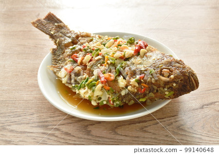 fried mango fish dressing spicy sauce herb sauce on plate fried mango fish dressing spicy sauce herb sauce on plate 99140648