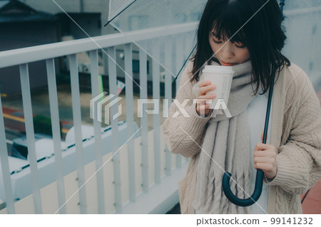 一位女士在立交橋上打傘喝咖啡等待開會的照片 99141232