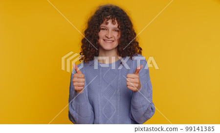 Happy woman raises thumbs up agrees or gives positive reply recommends advertisement likes good Happy woman raises thumbs up agrees or gives positive reply recommends advertisement likes good 99141385