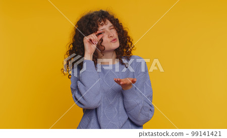 Woman showing a little bit gesture with sceptic smile, showing minimum sign, measuring small size 99141421