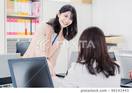Two female office workers consulting in the office Two female office workers consulting in the office 99141443