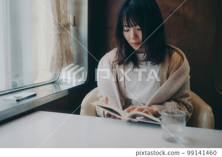 Photo of a woman reading in a coffee shop 99141460