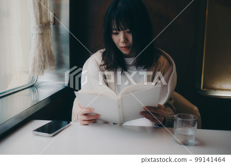Photo of a woman reading in a coffee shop 99141464