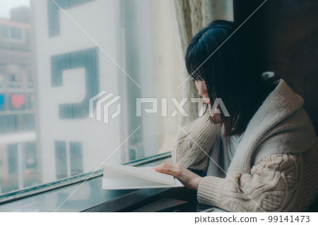 Photo of a woman reading in a coffee shop 99141473