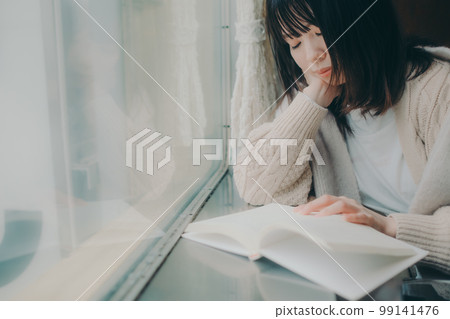 Photo of a woman reading in a coffee shop 99141476