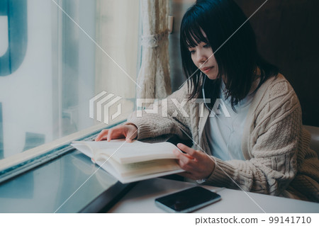一個女人在咖啡店看書的照片 一個女人在咖啡店看書的照片 99141710