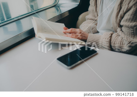 Photo of a woman reading in a coffee shop 99141718