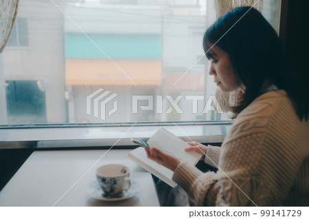一個女人在咖啡店看書的照片 一個女人在咖啡店看書的照片 99141729