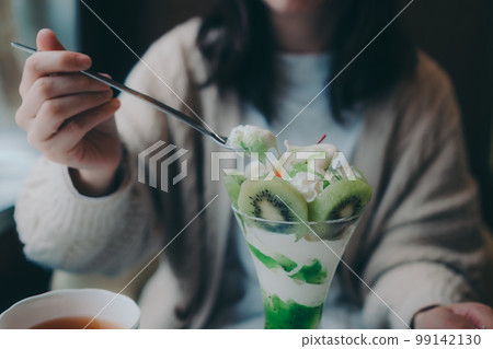 Photo of a woman eating a parfait at a coffee shop 99142130