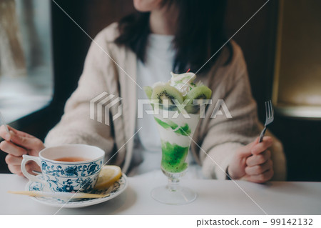 一位女士在咖啡店吃凍糕的照片 99142132