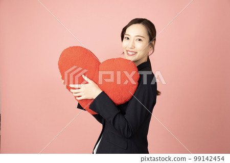 一個穿著海軍服的女人,帶著一顆紅色的心 一個穿著海軍服的女人,帶著一顆紅色的心 99142454