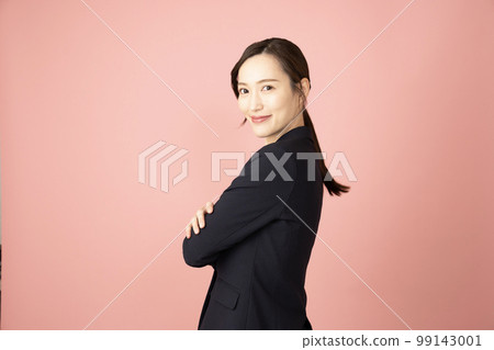 A woman who folds her arms in a pink back and turns around and smiles 99143001