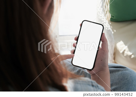 Mock up phone in woman hand showing white screen. Mobile phone white screen is blank the background is blurred Mock up phone in woman hand showing white screen. Mobile phone white screen is blank the background is blurred 99143452